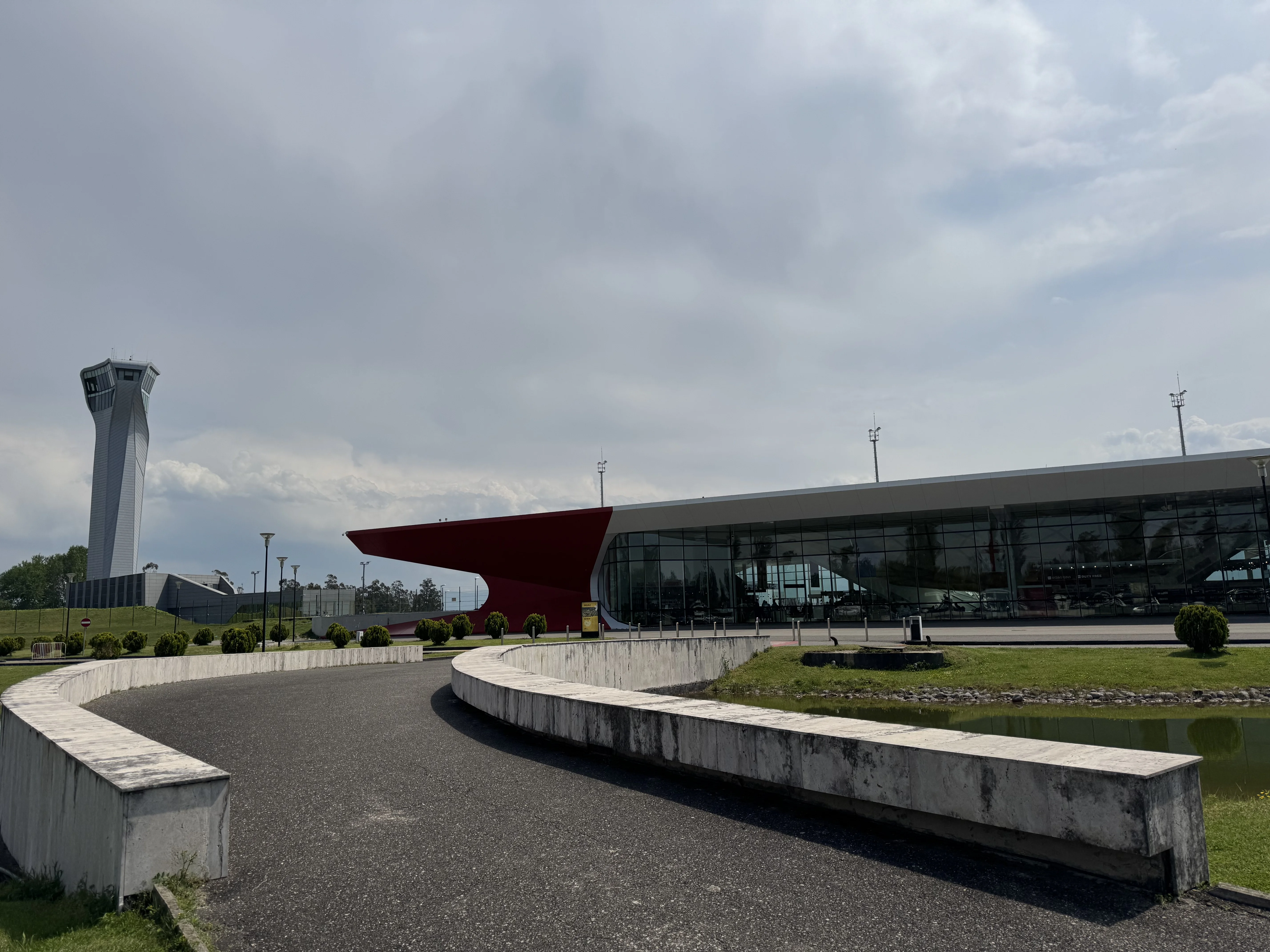 Airport Kutaisi front view: green surroundings, pathway, fassade of glass