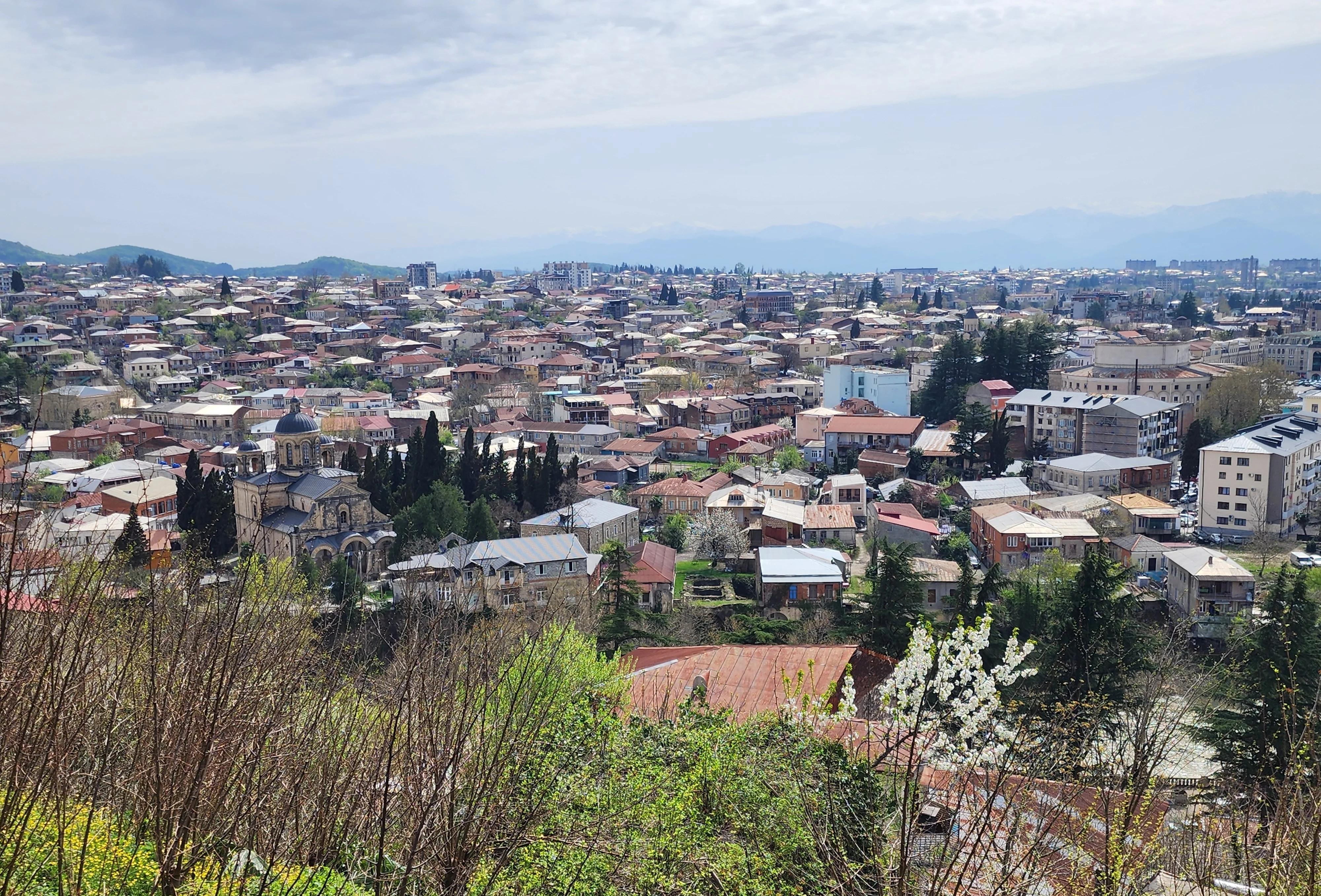 Kutaisi seen from Bagrati cathedral: spring time, rooftops, mountains in background