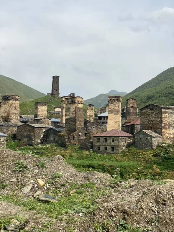 A village with several of the famous svan towers - one of them rising above the others on a rocky green hill
